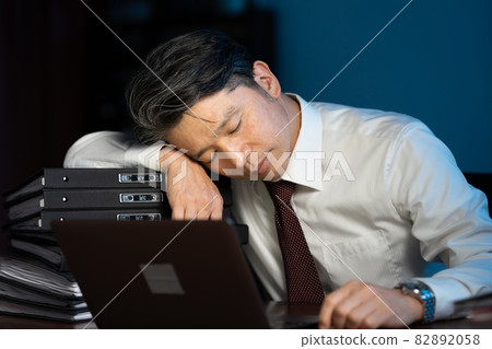 Businessman overtime, middle man, napping 82892058