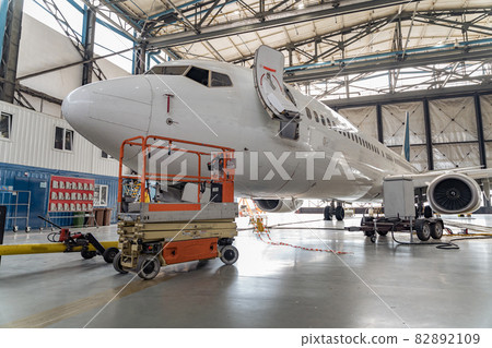 Passenger aircraft on maintenance of engine and fuselage repair in hangar 82892109