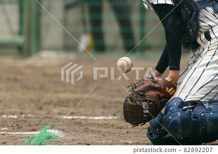 A catcher who stops the ball with his body trying to catch the ball thrown by the pitcher during a baseball game A catcher who stops the ball with his body trying to catch the ball thrown by the pitcher during a baseball game 82892207