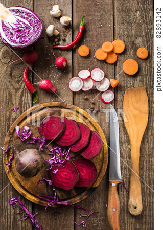 sliced vegetables on slate and wooden counter top background 82893142