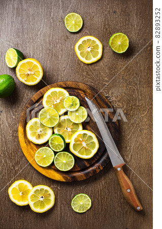 sliced on lemon, lime slate and wooden counter top background sliced on lemon, lime slate and wooden counter top background 82893252