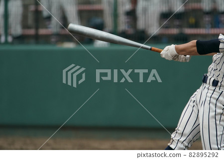 Left batter who hit the ball thrown by the pitcher and swung the bat during a baseball game 82895292