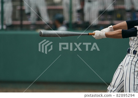 Left batter who hit the ball thrown by the pitcher and swung the bat during a baseball game 82895294