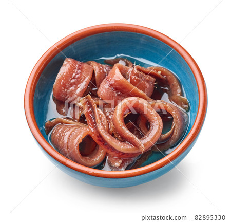 bowl of canned anchovy fillets 82895330
