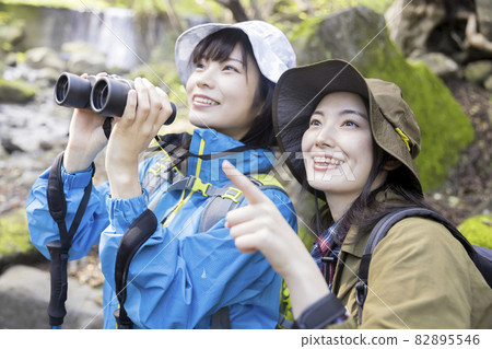 Trekking image of a young woman doing bird watching Trekking image of a young woman doing bird watching 82895546
