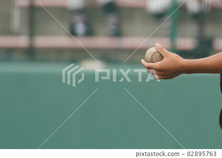 A player trying to give the ball to a knocker while knocking on a baseball seat A player trying to give the ball to a knocker while knocking on a baseball seat 82895763