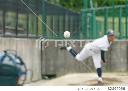 A white ball thrown by a pitcher who practices pitching to warm his shoulders with a bullpen during a baseball game 82896066