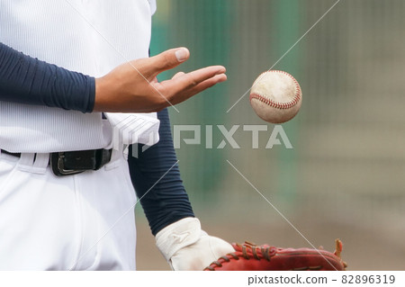 At the hands of a player who throws a ball into a glove during a seat knock before a baseball game 82896319
