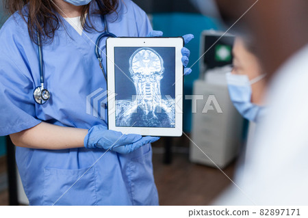Closeup of therapist woman asisstant holding tablet computer with radiograpy Closeup of therapist woman asisstant holding tablet computer with radiograpy 82897171