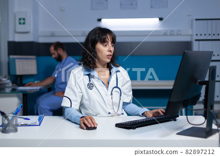 Medical specialist using computer and keyboard at night Medical specialist using computer and keyboard at night 82897212