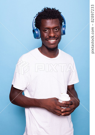 Man wearing headphones while smiling and looking at camera 82897233
