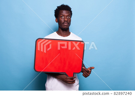African american man holding red speech bubble in studio African american man holding red speech bubble in studio 82897240