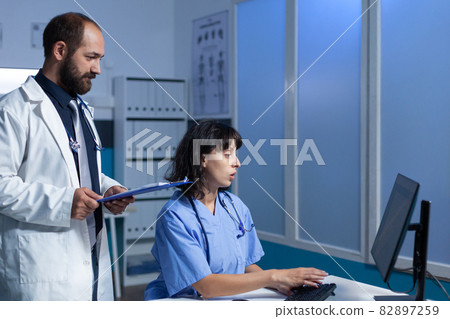 Medical team of workers looking at monitor for healthcare 82897259