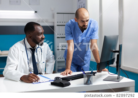 African american physician doctor monitoring ill expertise on computer African american physician doctor monitoring ill expertise on computer 82897292