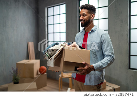 Happy young man holding packing boxes moving home, new living concept. 82897471