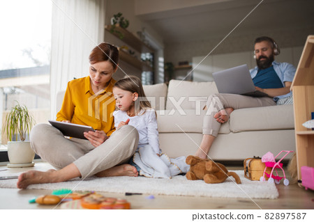 Mother with small daughter using tablet indoors at home, everyday life and home office with child concept. Mother with small daughter using tablet indoors at home, everyday life and home office with child concept. 82897587