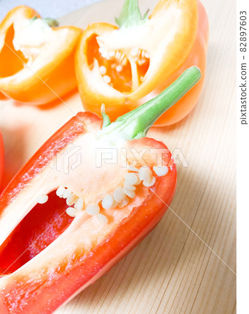 4個辣椒粉在砧板上切成兩半紅色，橙色 82897603