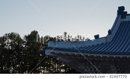 有雕塑的屋簷在樹的背景中 有雕塑的屋簷在樹的背景中 82897770