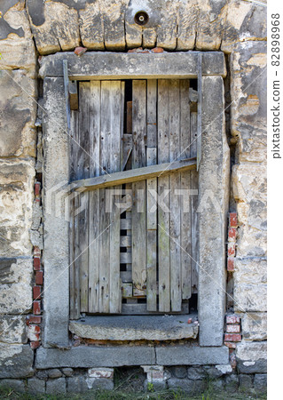 A damaged door in an abandoned building A damaged door in an abandoned building 82898968