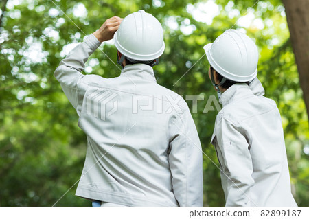 身著工作服的年輕男女站在森林裡 82899187