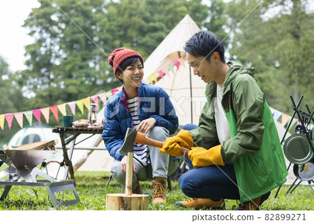 Young men and women enjoying camping 82899271