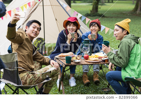 Young men and women enjoying camping Young men and women enjoying camping 82899366