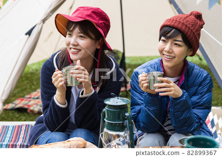 Young men and women enjoying camping Young men and women enjoying camping 82899367