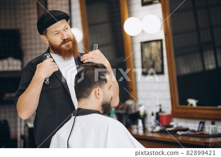 Professional barber, clipper making hair cut to customer, young man at barbershop. Beauty, selfcare, style, fashion and male cosmetics concept. 82899421