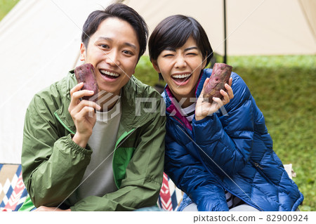 Young men and women enjoying camping 82900924
