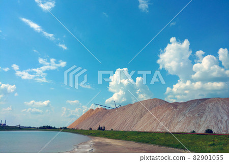 A large mountain of spent ore against the background of a blue sky. A large mountain of spent ore against the background of a blue sky. 82901055