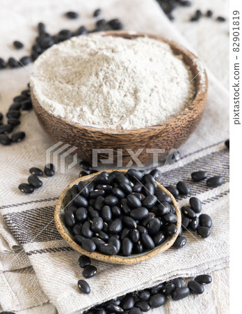 Ceramic bowls with black beans flour with a wooden spoon Ceramic bowls with black beans flour with a wooden spoon 82901819
