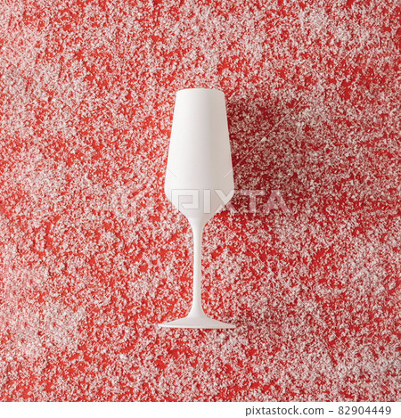Pure white champagne glass over a red Christmas background 82904449