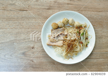 boiled dry vermicelli thin rice noodles topping slice pork and meatball dressing sweet black soybean sauce on plate 82904839