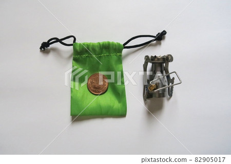 A tiny backpacking stove with a 10-yen coin for size reference. 82905017