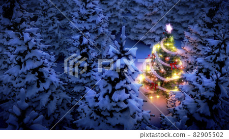 lightened christmas tree surrounded by snow-covered pine trees at night lightened christmas tree surrounded by snow-covered pine trees at night 82905502