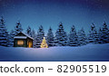 lightened christmas tree in front of wooden cabin in snow at night with pine trees in background 82905519