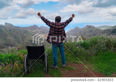 Disabled handicapped woman in wheelchair on mountain hill enjoying view 82905883