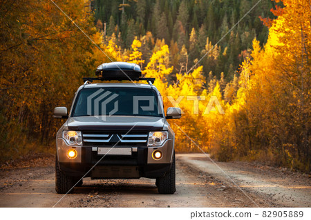 Mitsubishi Pajero on scenic autumn road in the forest 82905889