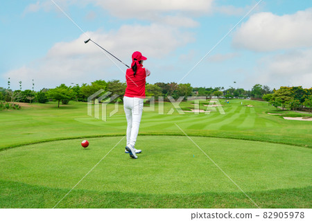 woman Golfer Hitting Ball with Club on Beatuiful Golf Course woman Golfer Hitting Ball with Club on Beatuiful Golf Course 82905978