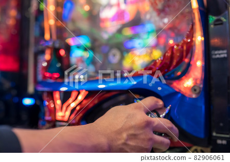 Hands playing on a pachinko machine 82906061