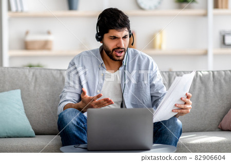 Young arab man having video conference, working with financial documents, discussing annual reports, having problems Young arab man having video conference, working with financial documents, discussing annual reports, having problems 82906604