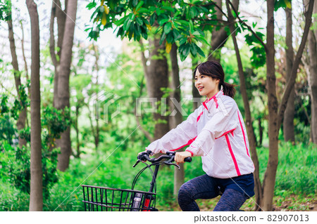 Young woman enjoying cycling in nature Young woman enjoying cycling in nature 82907013