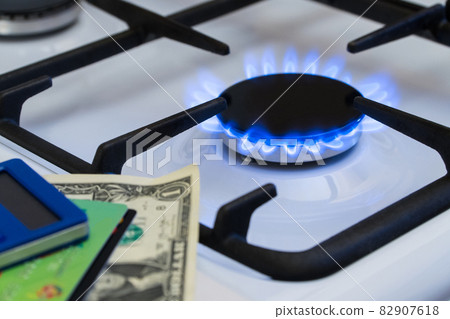 Shortage and gas crisis. Money and a calculator on the background of a burning gas stove 82907618