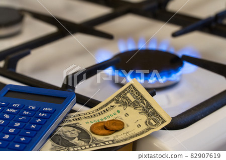Shortage and gas crisis. Money and a calculator on the background of a burning gas stove 82907619