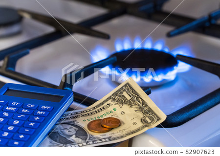 Shortage and gas crisis. Money and a calculator on the background of a burning gas stove 82907623