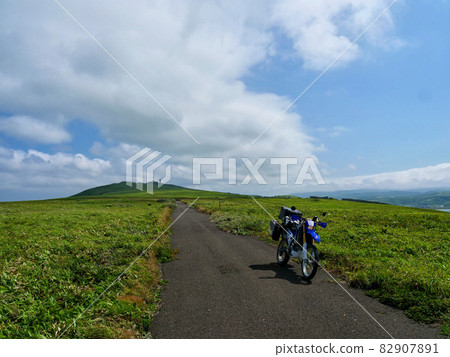 A straight road and a motorcycle leading to the blue sky and hills A straight road and a motorcycle leading to the blue sky and hills 82907891