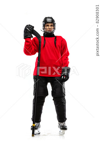 Full-length portrait of woman, professional hockey player in special protective uniform with helmet and hockey stick isolated over white background. 82908301