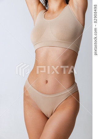 Close-up image of fit female body in underwear isolated over gray background. 82908498
