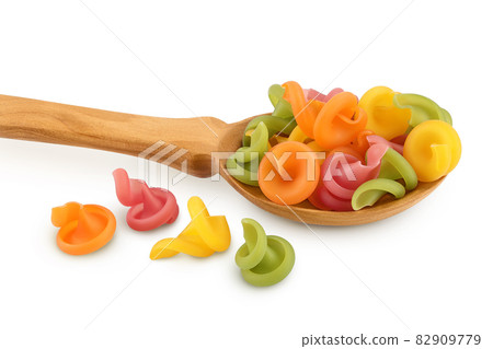 Raw colored pasta in wooden spoon isolated on white background with clipping path and full depth of field 82909779