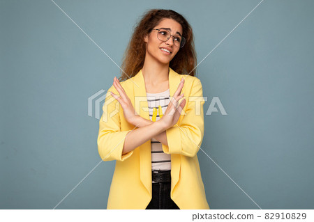 Photo of young emotional attractive brunette curly woman with sincere emotions wearing stylish Photo of young emotional attractive brunette curly woman with sincere emotions wearing stylish 82910829
